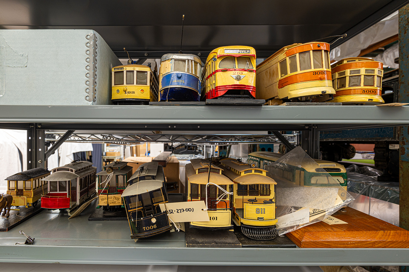 Toy trains on grey shelving.
