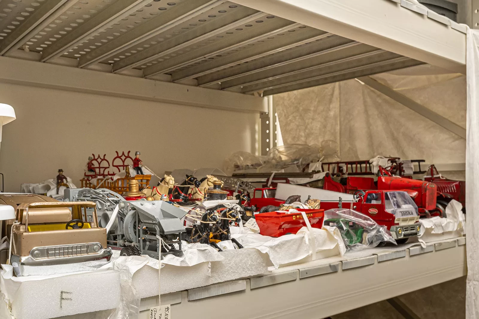 A collection of vintage toy trucks on a shelf.